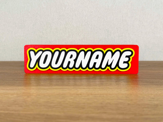 Picture of a lego name sign on a wooden desk or bedroom table