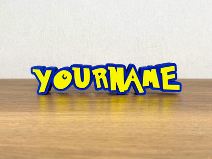 Picture of a pokemon cartoon name sign on a wooden desk or bedroom table