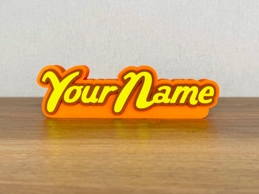 Picture of a reeses peanut butter chocolate name sign on a wooden desk or bedroom table