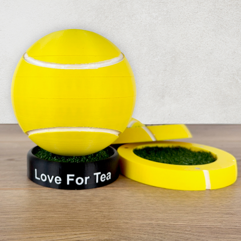 A picture of 4 drinks coasters, with artificial grass inserts  in the shape of a tennis ball on a wooden work surface