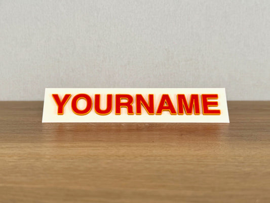 Picture of a toblerone name sign on a desk or bedroom table